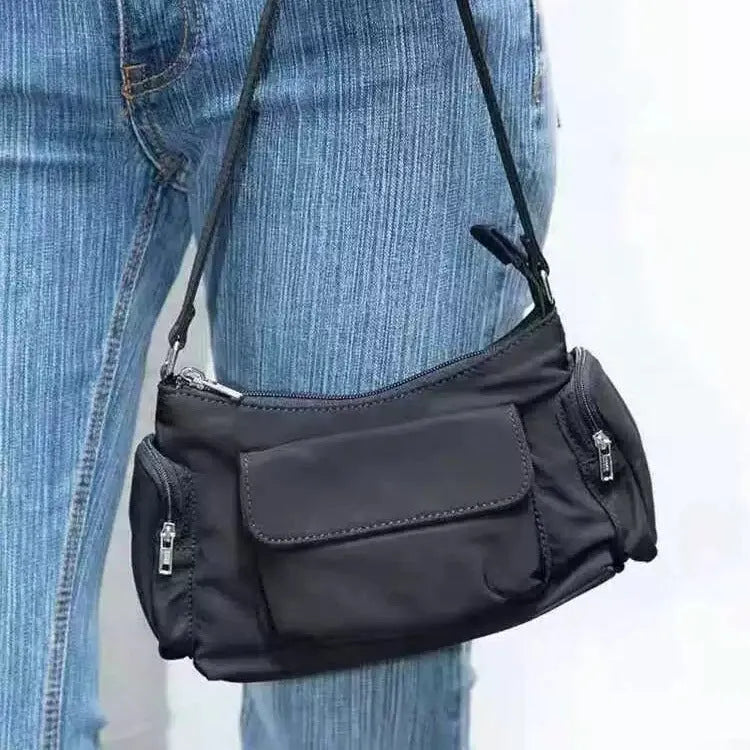 Black shoulder bag with two pockets showing side line detailing, measuring 24cm long by 9cm wide