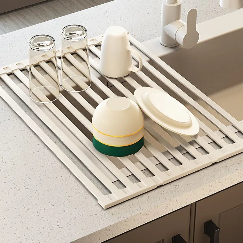 Milky white foldable stainless steel kitchen draining rack with tri-fold design on a sink