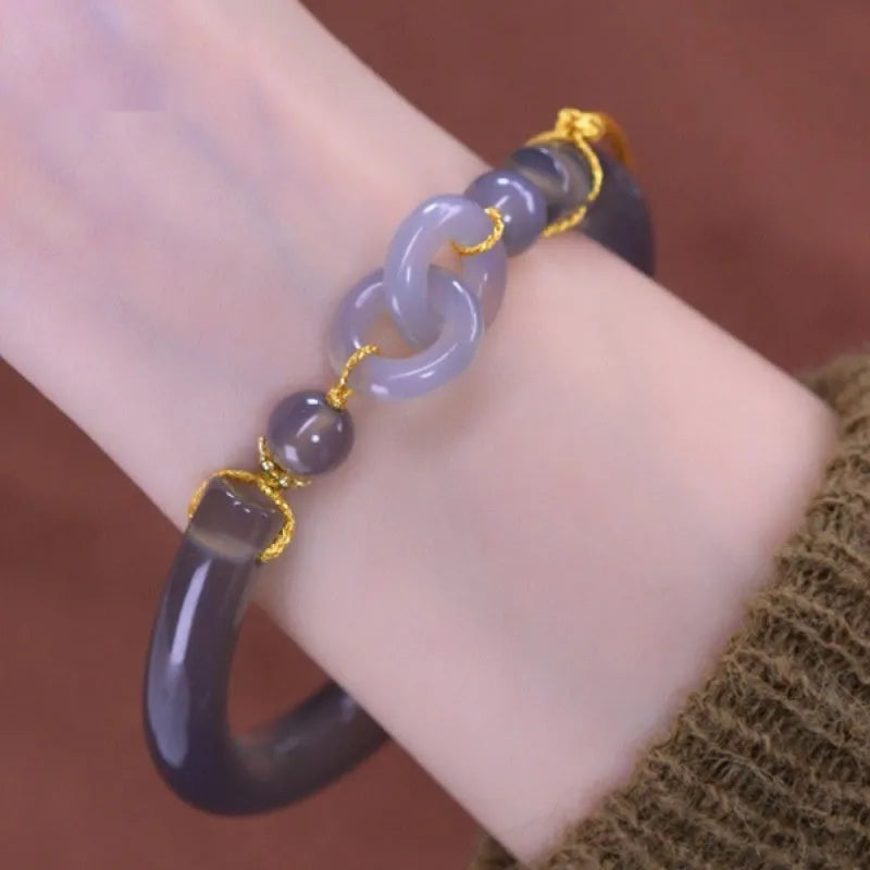 Close-up of a smoke purple grey agate half bracelet with a metal ring buckle closure on a wrist.