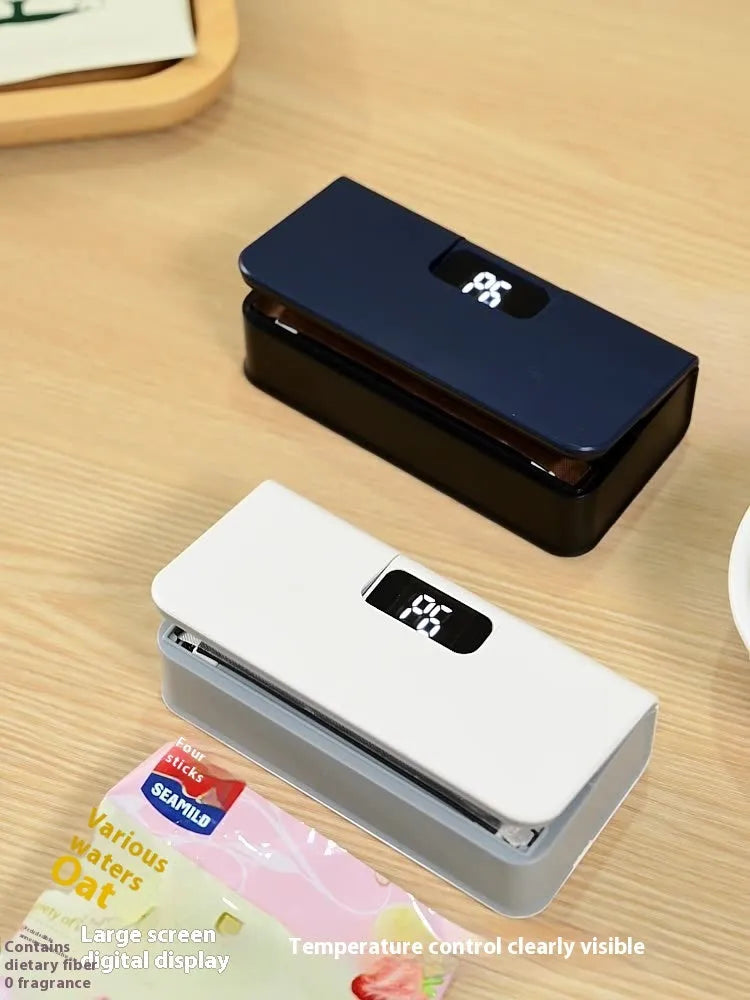 Small white portable heat sealing machine for plastic food bags on a kitchen counter.