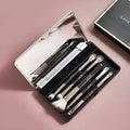 Portable makeup brush set with mirror showing artificial fibre brush heads and silver/gold plastic handles