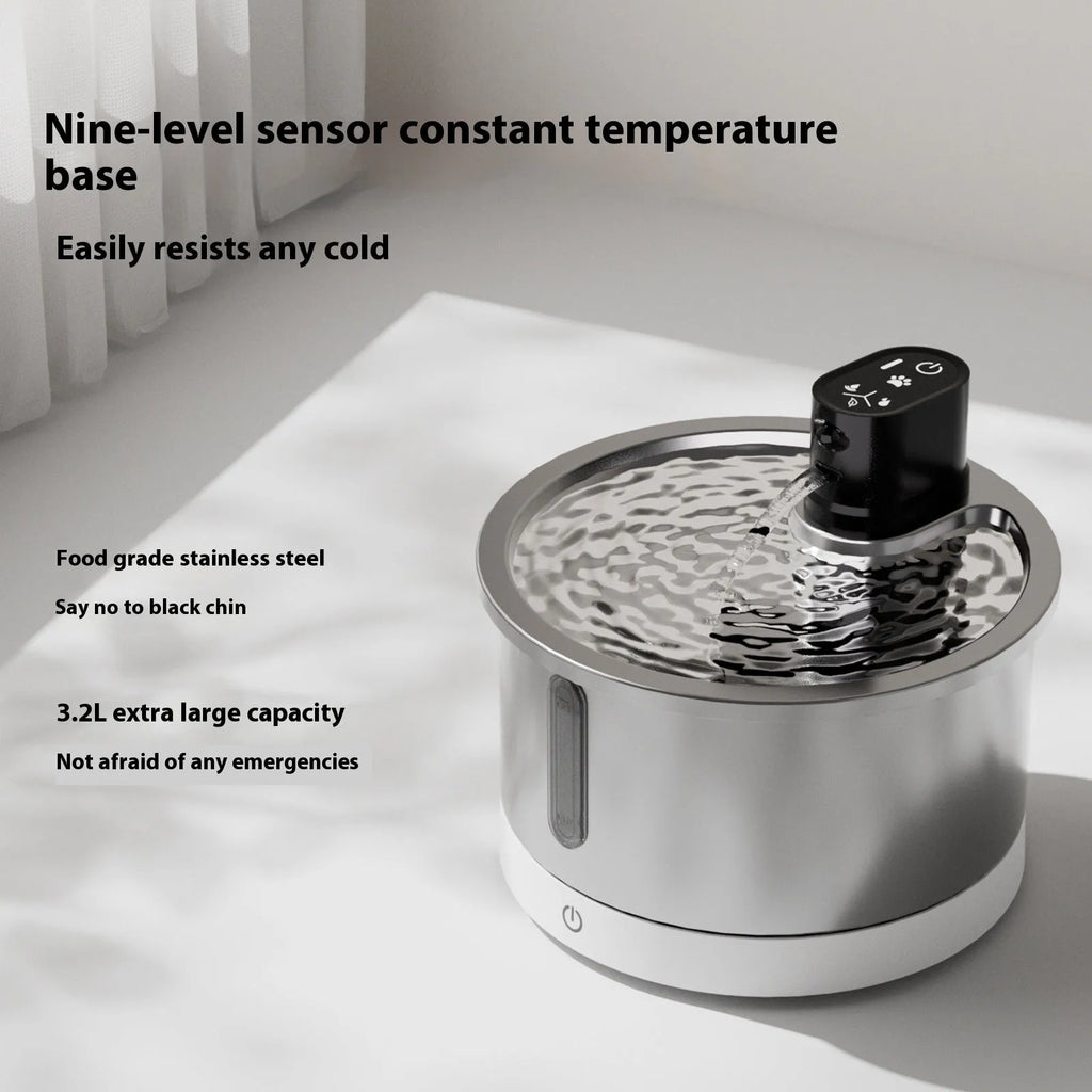 White stainless steel cat water fountain with heating base and USB cable on a kitchen floor