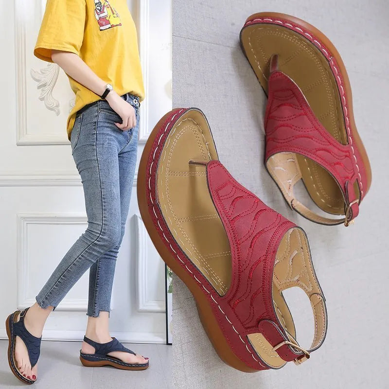 Women's casual wedge heel flip flop sandals with an adjustable buckle strap on the back, shown in a solid colour.