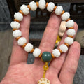 Hand-carved Bodhi root bracelet with White Jade beads, lotus carvings, and a cat's paw pendant.