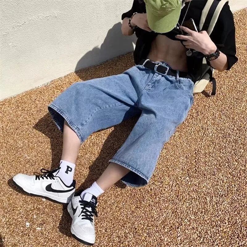 Men's blue washed denim shorts with high waist, cropped length, and straight-leg design on a model