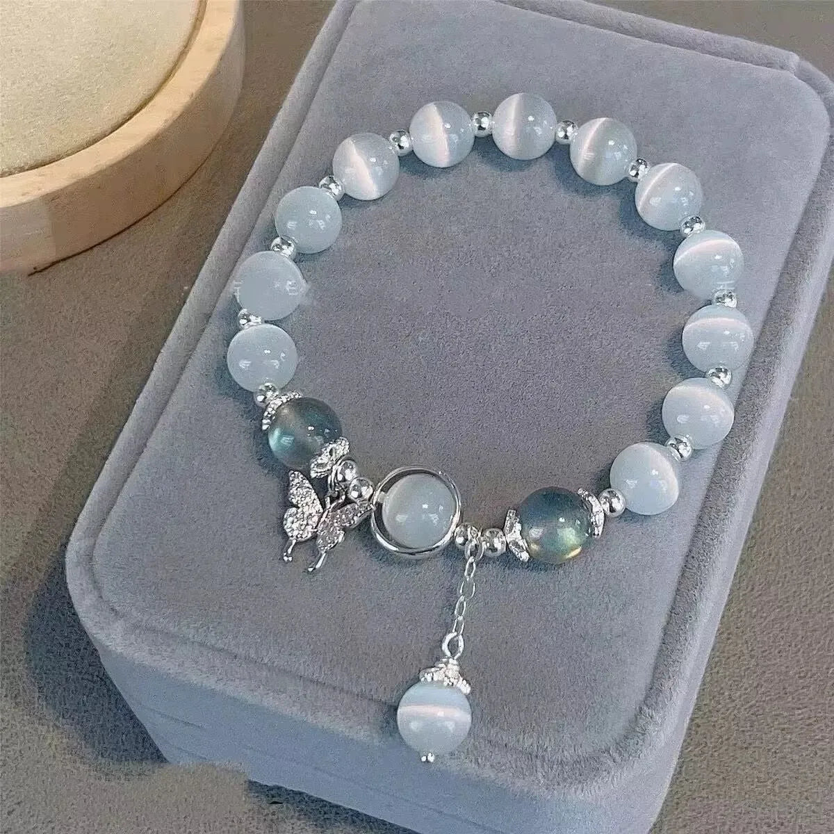 Glass butterfly bracelet for women with drop shape design and round decorative elements in moonlight grey colour
