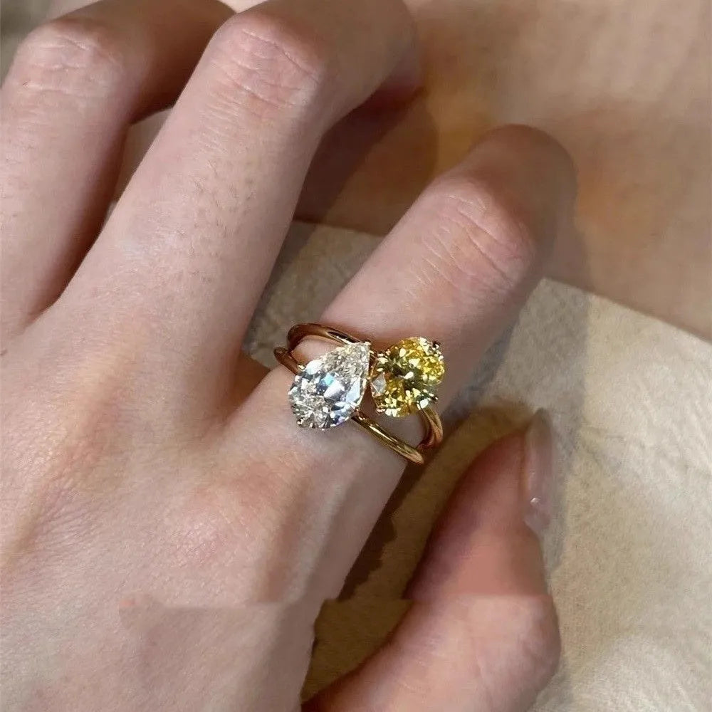 Geometric open copper ring with central water drop double Sheng stone accent on woman's finger