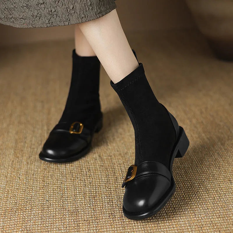 Women's black low heel Martin boots with lace-up front and belt buckle detail.
