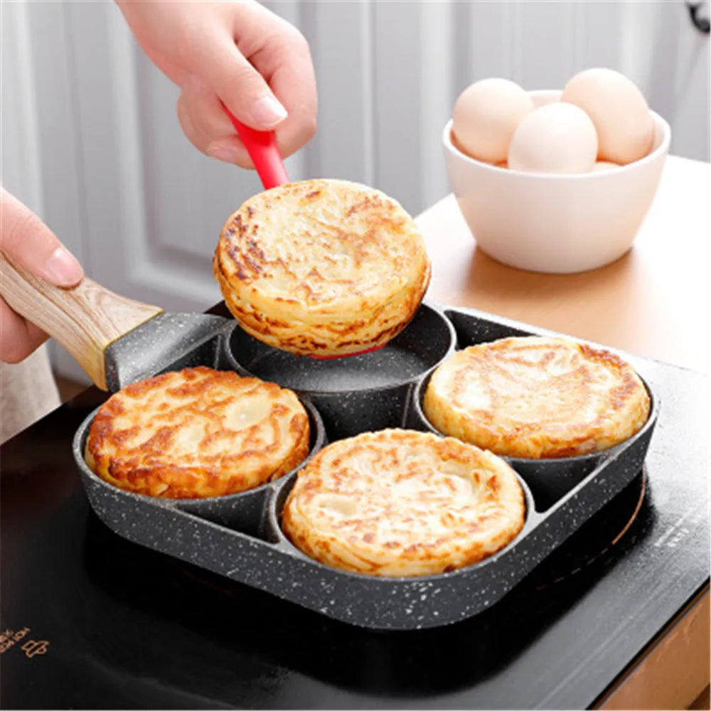 Aluminium four-hole non-stick frying pan with optional silicone spatula and brush on a hob