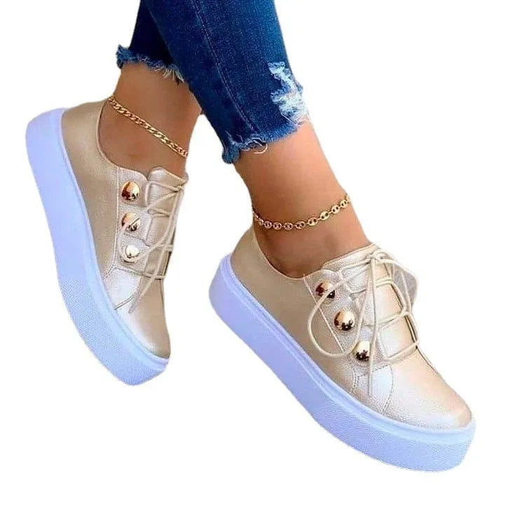 Women's white lace-up flats sneakers with rivet detailing on round toe, showing front tie lacing and 3-5cm heel