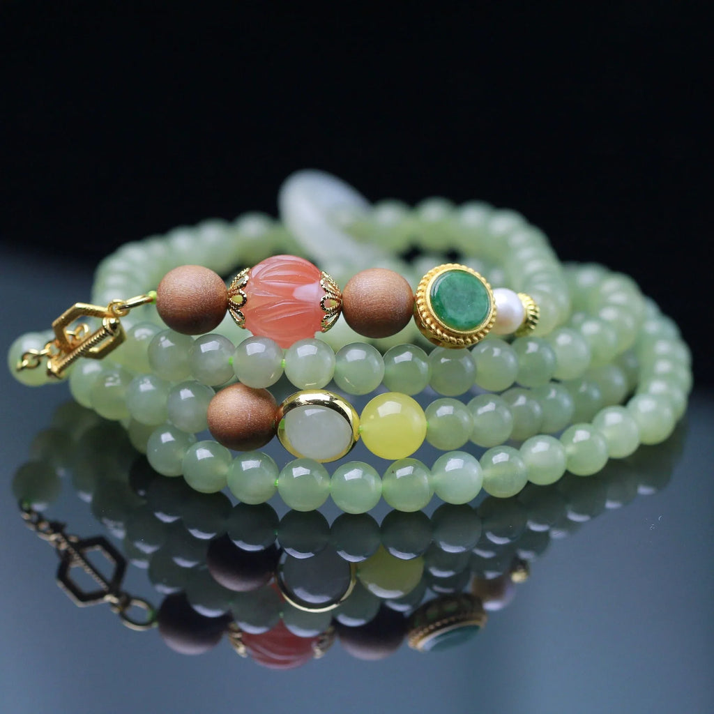 Hetian jade and red lotus bead necklace with matching bracelet on white sandalwood and beeswax.