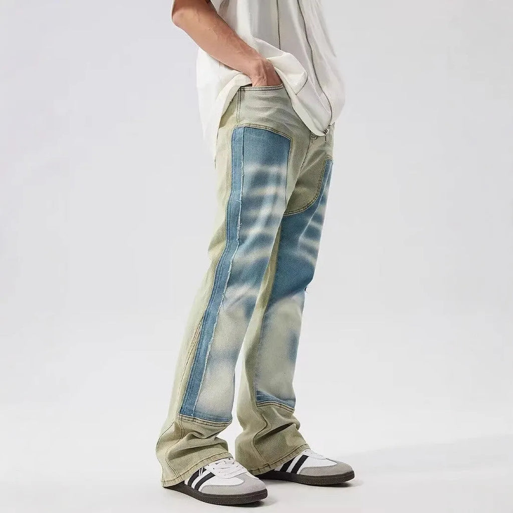 Retro dual-colour patchwork jeans with yellow and blue sections, splash-ink patterns, and distressed detailing on mid-waist denim trousers