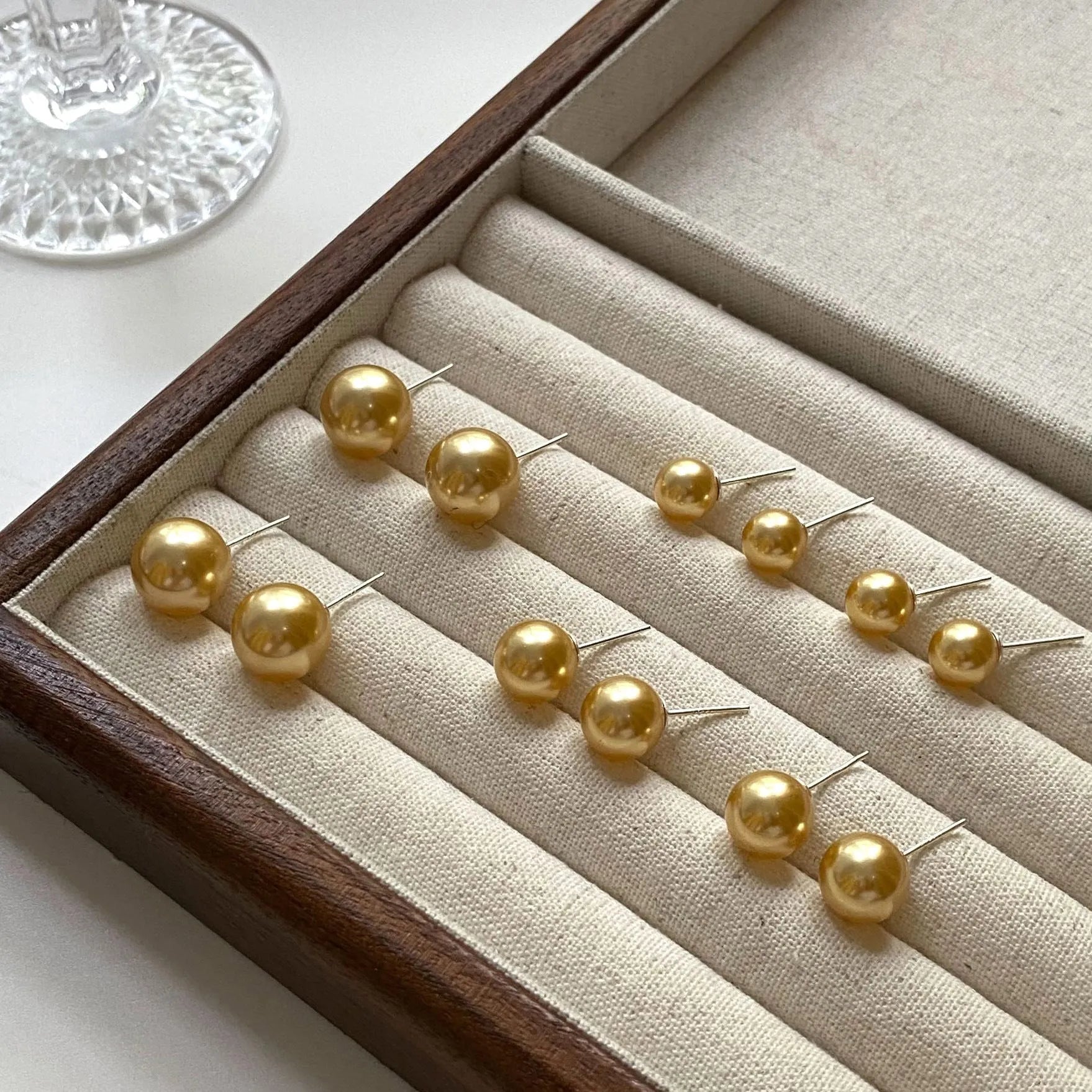 Large pearl stud earrings with geometric eight-point star setting in silver, showing four size options from 8mm to 14mm