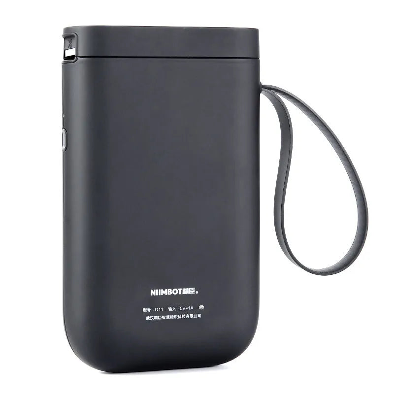 D11 compact Bluetooth thermal label printer in black on a desk next to a smartphone showing the control app.