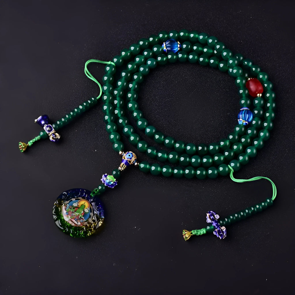 Green agate beaded bracelet with a multi-circle 108-bead thangka pendant on a wrist.