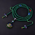 Green agate beaded bracelet with a multi-circle 108-bead thangka pendant on a wrist.