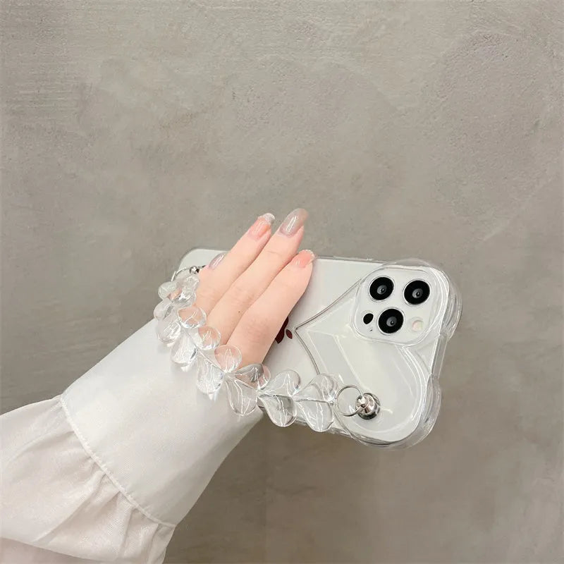 Transparent iPhone case with a soft TPU build and an integrated love heart chain, shown on a phone.