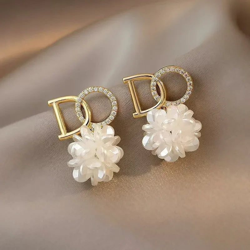 White DO letter embroidered ball earrings for women, trendy drop style with letter and ball detail.