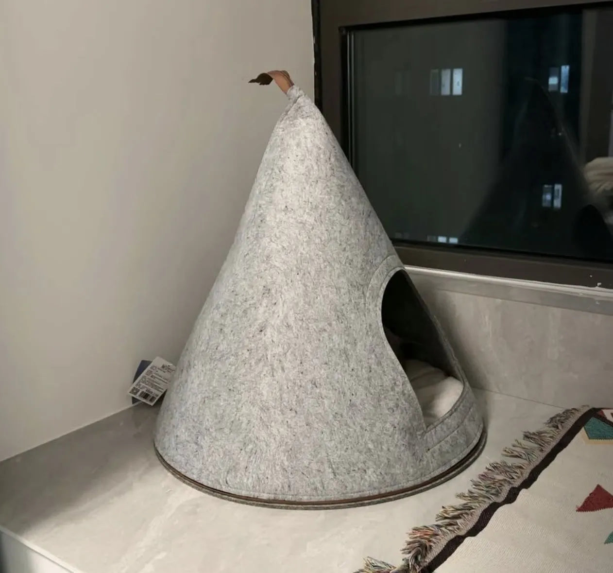 Grey conical felt cat house for indoor cats under 12 pounds.