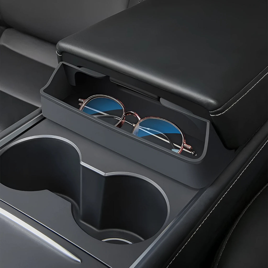 Black silicone sunglasses case installed inside a Tesla Model 3 or Y centre console armrest.