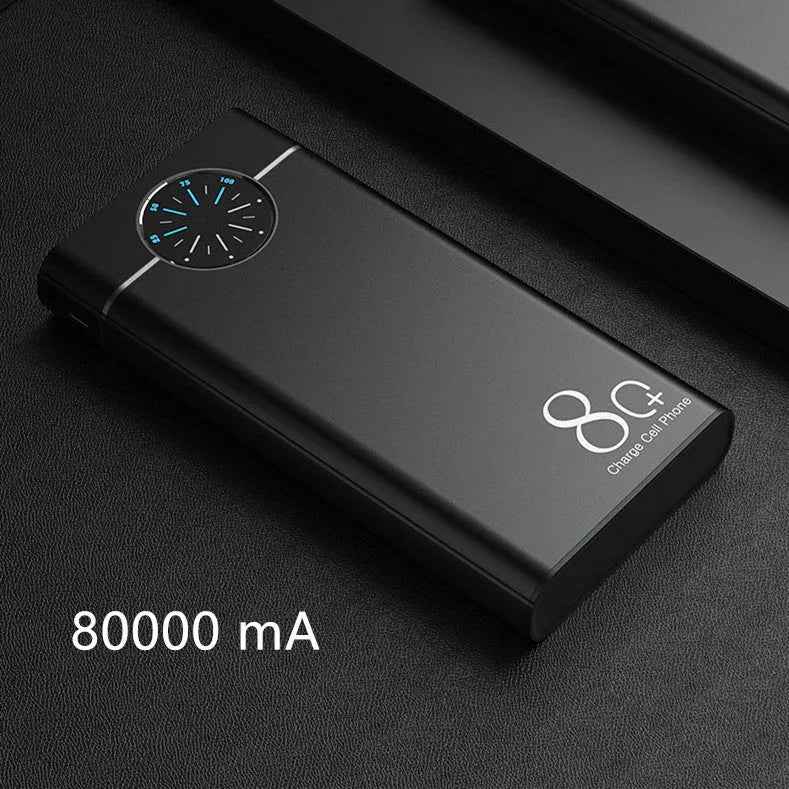 Black fast charging 20000mAh power bank with alloy shell and LED flashlight on a table.