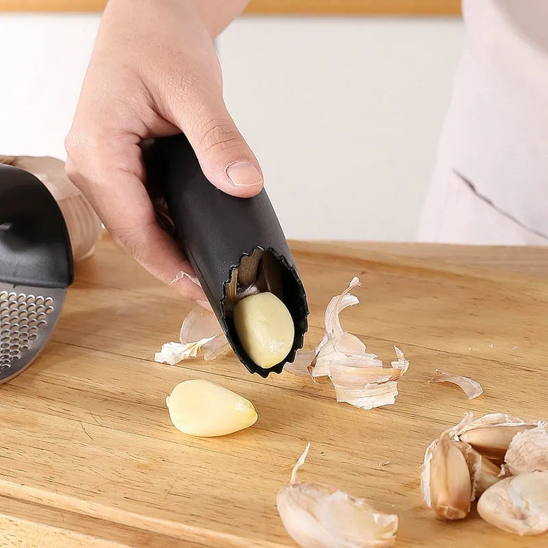 Stainless steel garlic press in green colour with ergonomic handle, measuring 11cm by 7cm on a kitchen counter