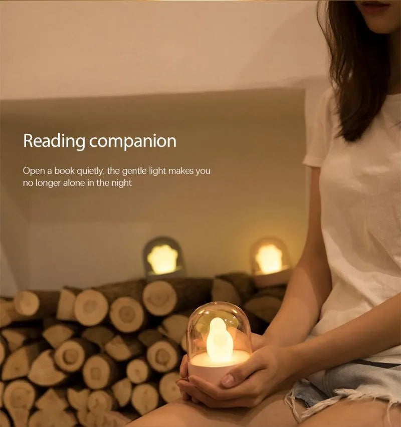 Grey cat paw shaped night light with USB charging port and control button showing soft illumination