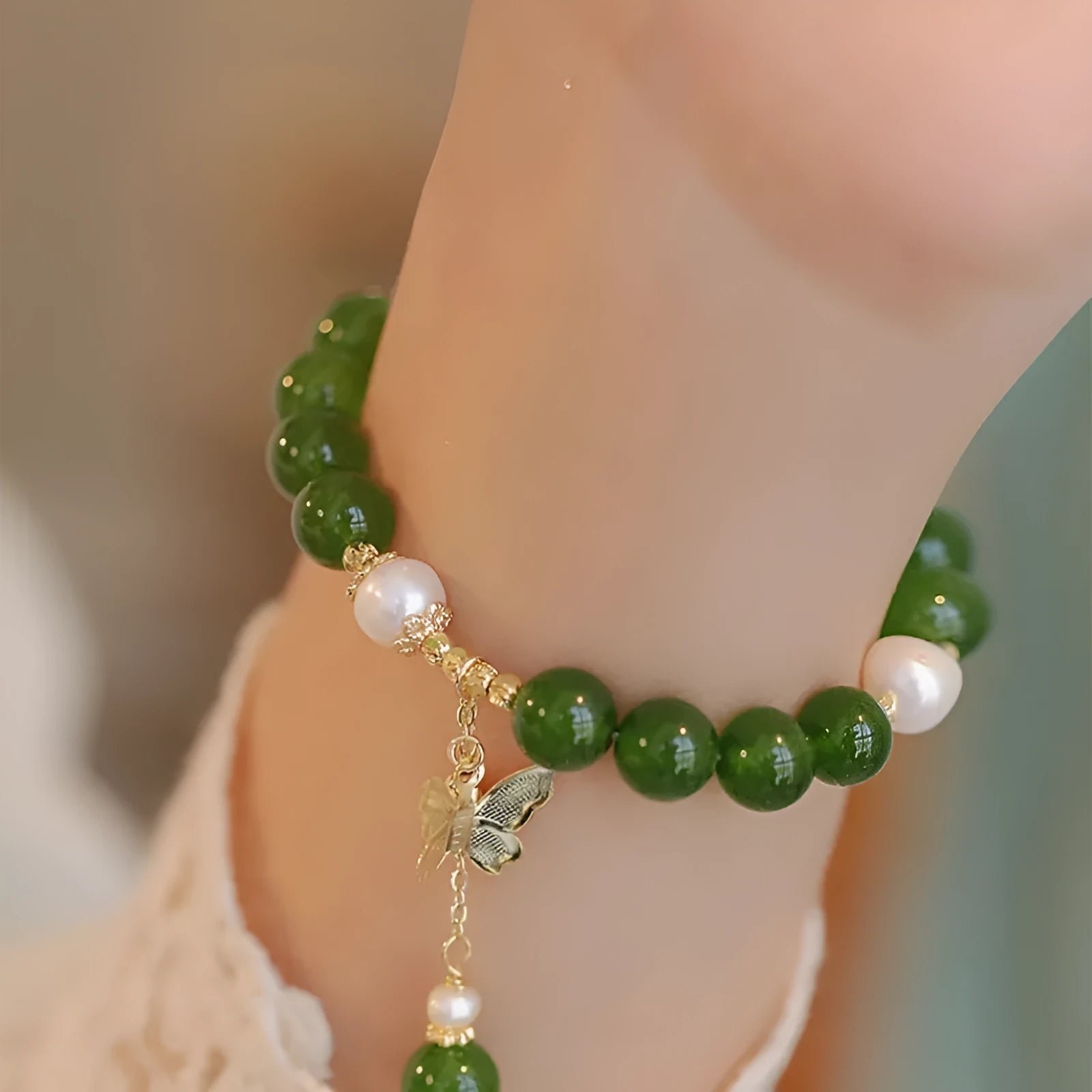 Green chalcedony bracelet with geometric round beads on a wrist.