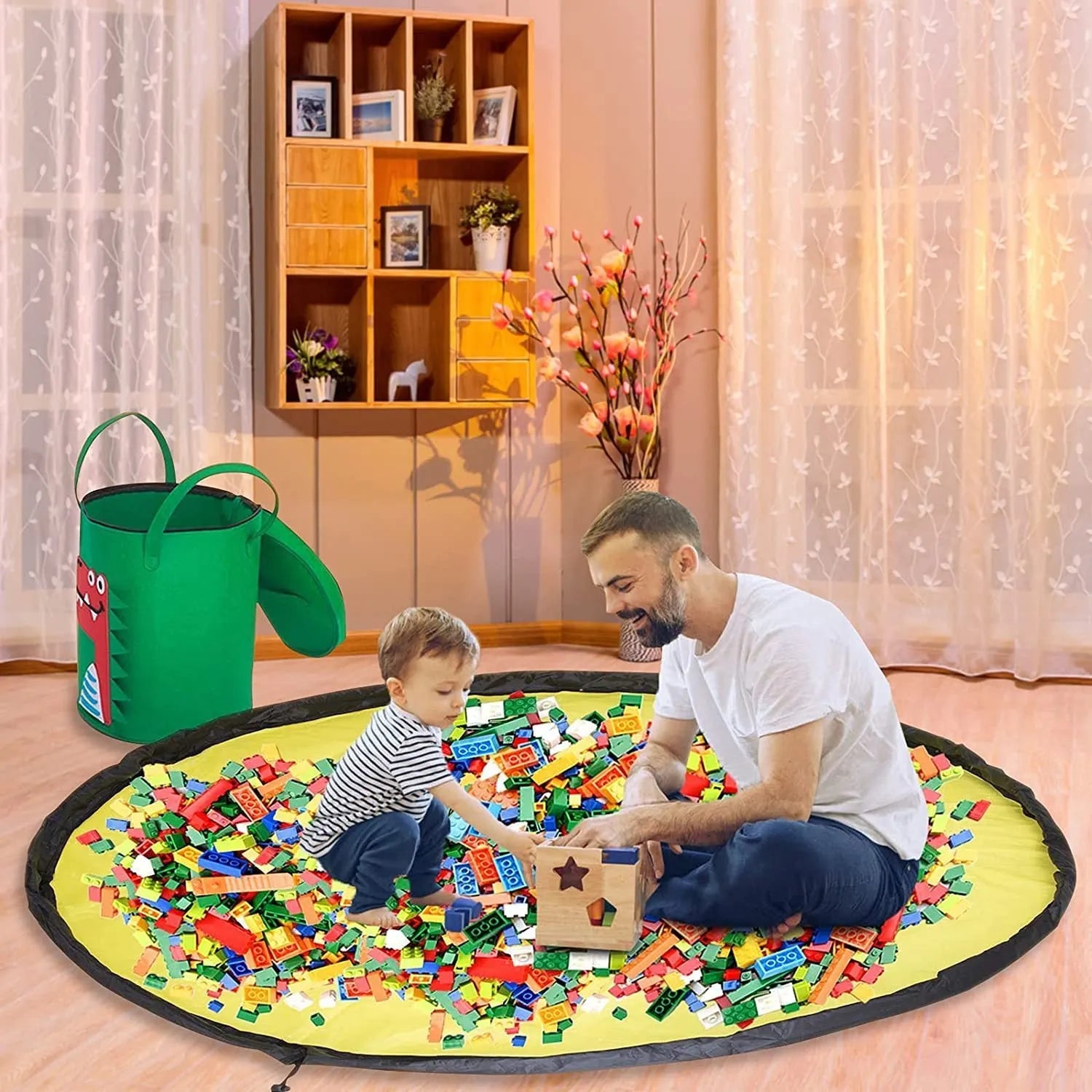 Green felt storage cube with pull rope, unfolded as a play mat on a living room floor