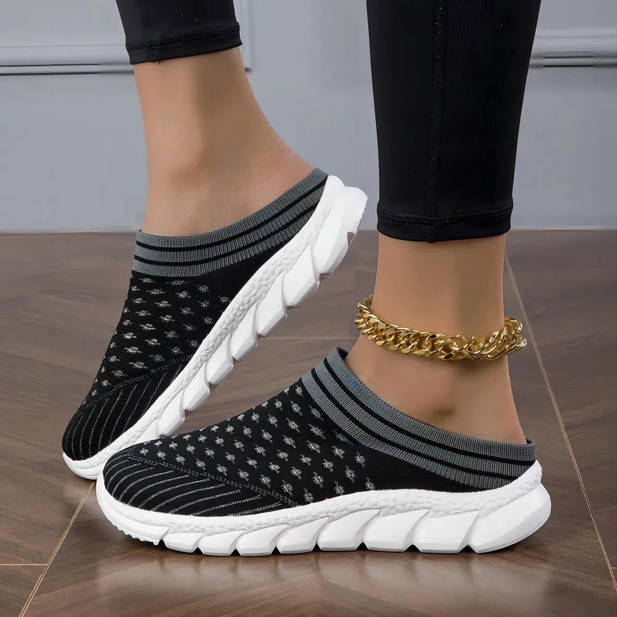 Women's black Flyknit slipper shoes with striped pattern and hollowed-out design on a white background.