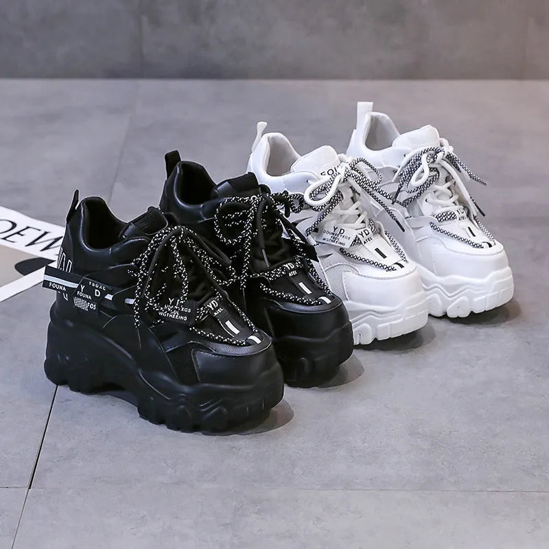 Women's white low-top platform sports shoes with cross strap and rubber sole on a light background