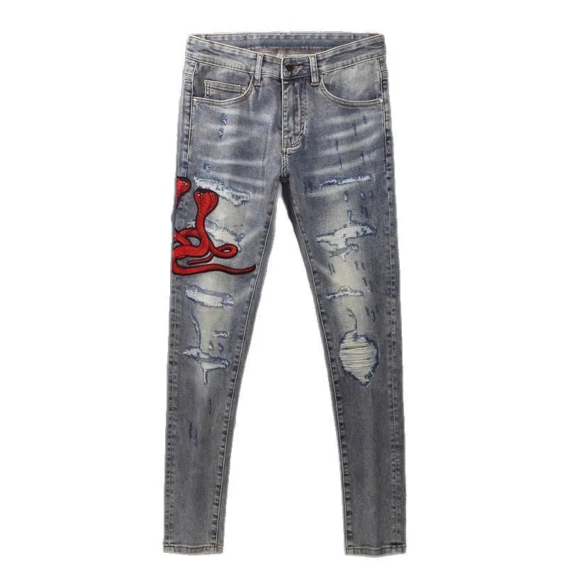 Men's slim fit distressed jeans with embroidered patches in an old colour wash.