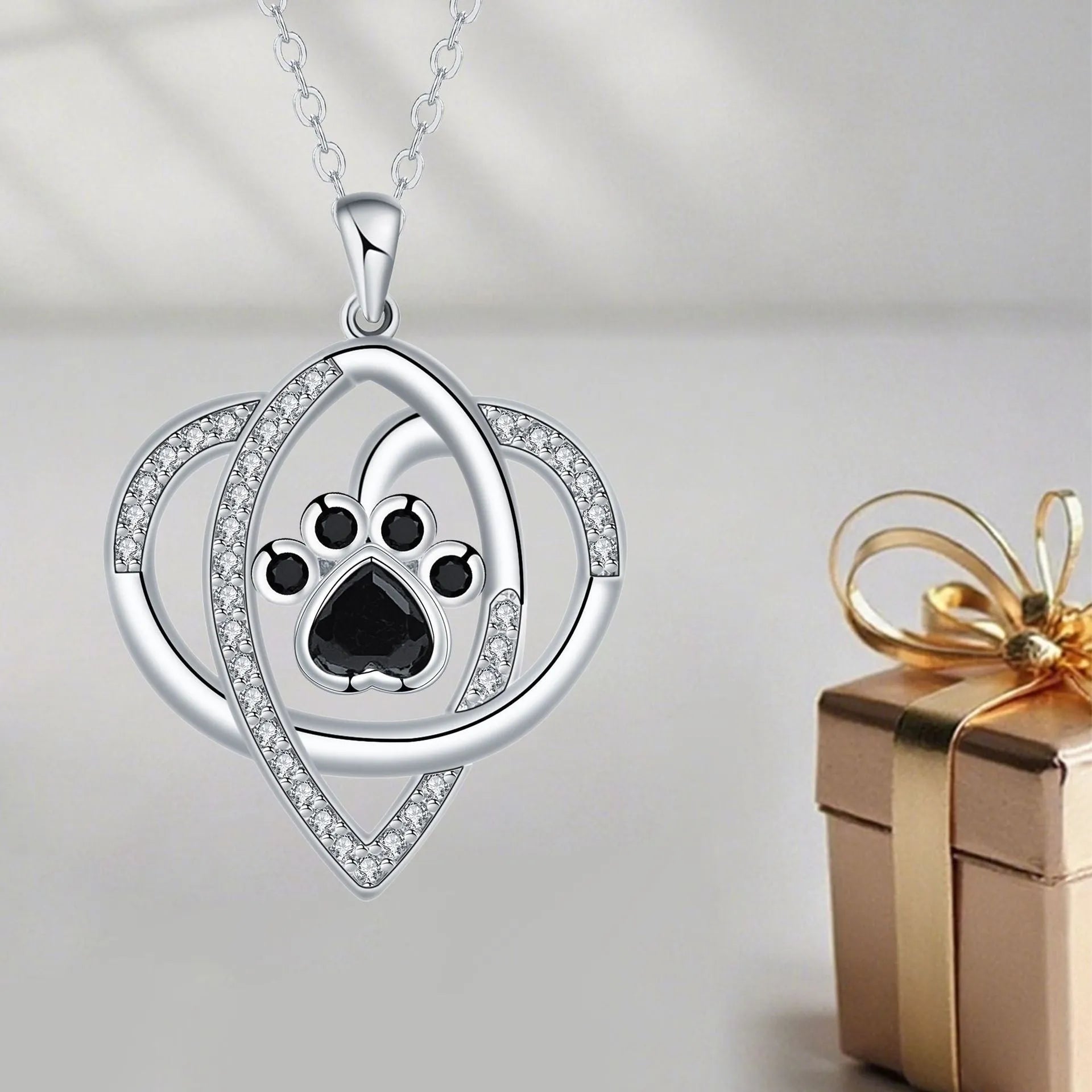 Copper pendant necklace showing cat and dog paw prints on a delicate cross chain.