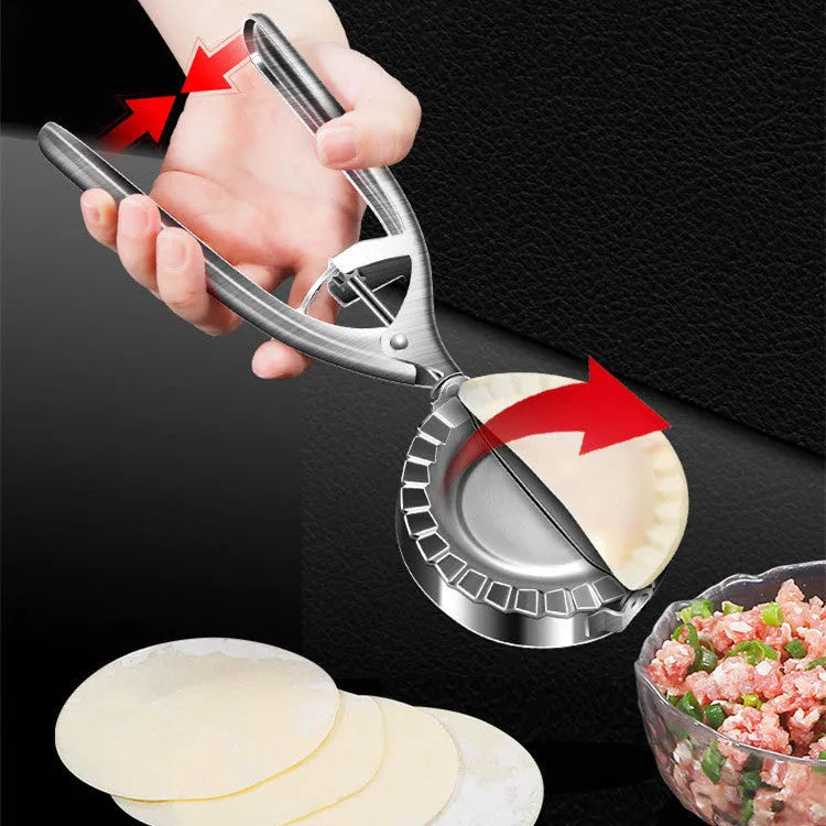 Silver stainless steel manual dumpling press mould with handle on a kitchen worktop.
