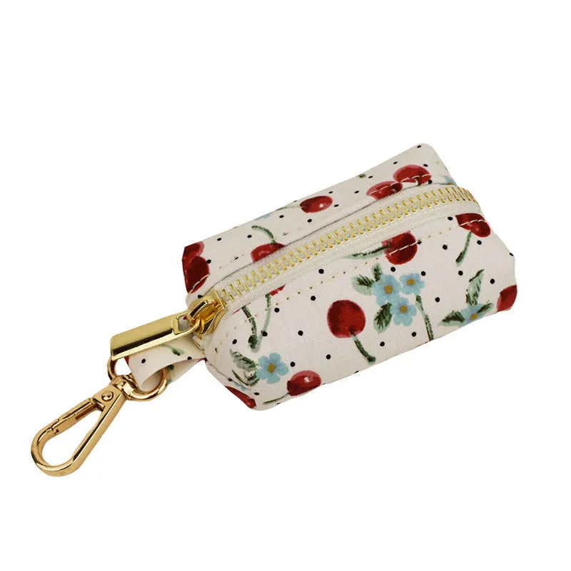 Red cherry printed cloth dog collar and leash set with matching vest, light gold buckle, and decorative bow strap.