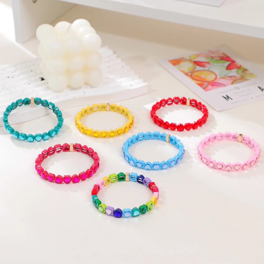 Colourful enamel heart charm on a stretch alloy bracelet.
