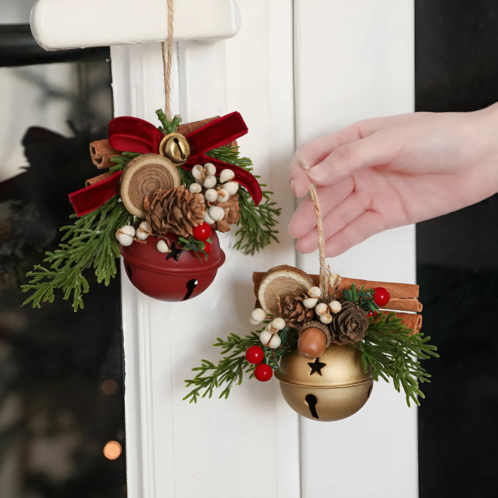 Wrought iron window hanging ornament with a jingling bell, antlers, and pine cone design in a choice of colours.