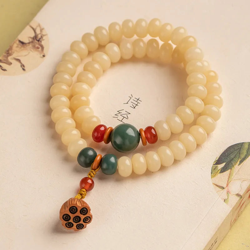 Cream topaz wooden bodhi root bracelet with 6x9mm flat round beads on wrist