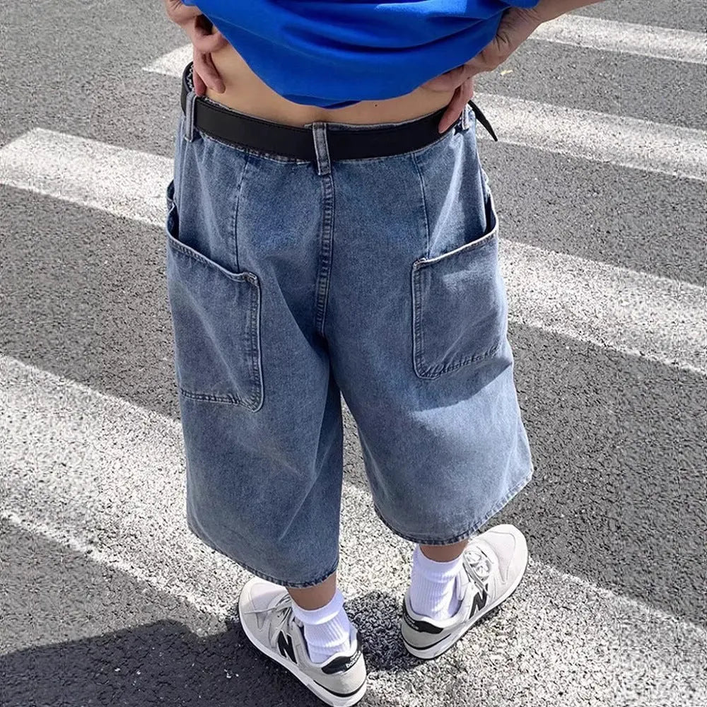Men's blue washed denim shorts with high waist, cropped length, and straight-leg design on a model