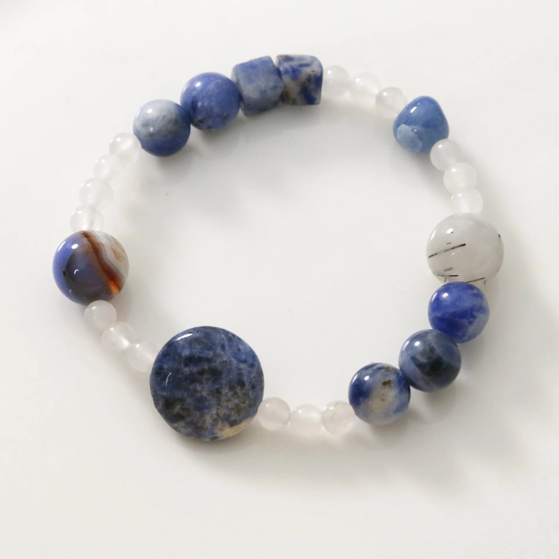 Hand-woven natural stone bracelet with blue point stone and black hair crystal agate in geometric design