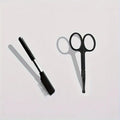 Black ambidextrous pet grooming brush with soft bristles for tear stains and a comb end for hair removal.