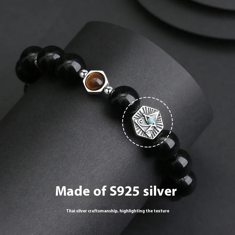 Men's S925 sterling silver bracelet with an 8mm geometric obsidian God's Eye centrepiece on a wrist.