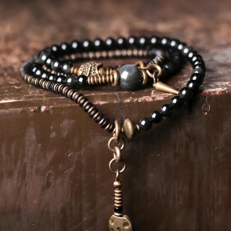 Black multi-layered beaded bracelet with colourful geometric and natural style beads.