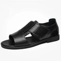Men's black leather sandals with open-toe design and non-slip rubber soles on a beach background