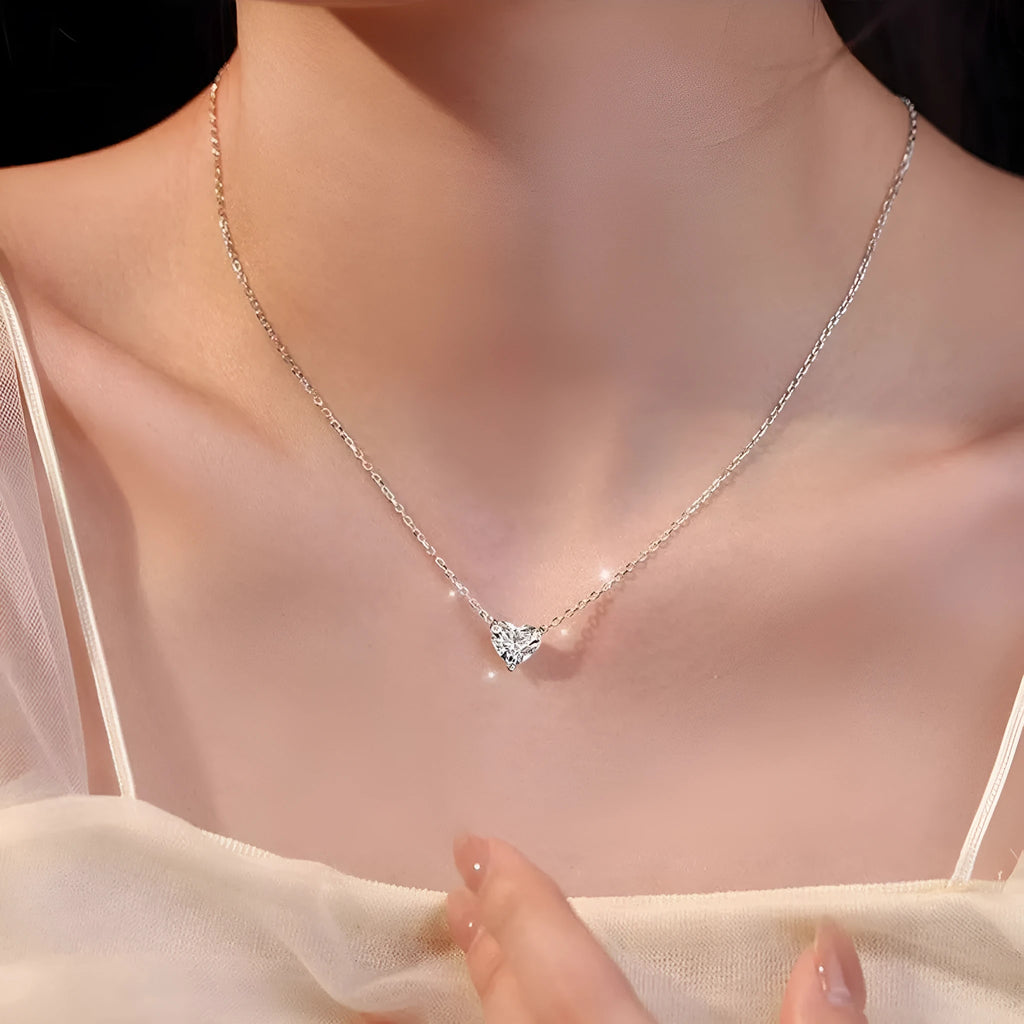 Simple silver-coloured women's necklace with a small love heart pendant on a chain.