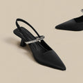 Black women's stiletto sandals with a pointed closed toe and a buckle strap around the ankle.