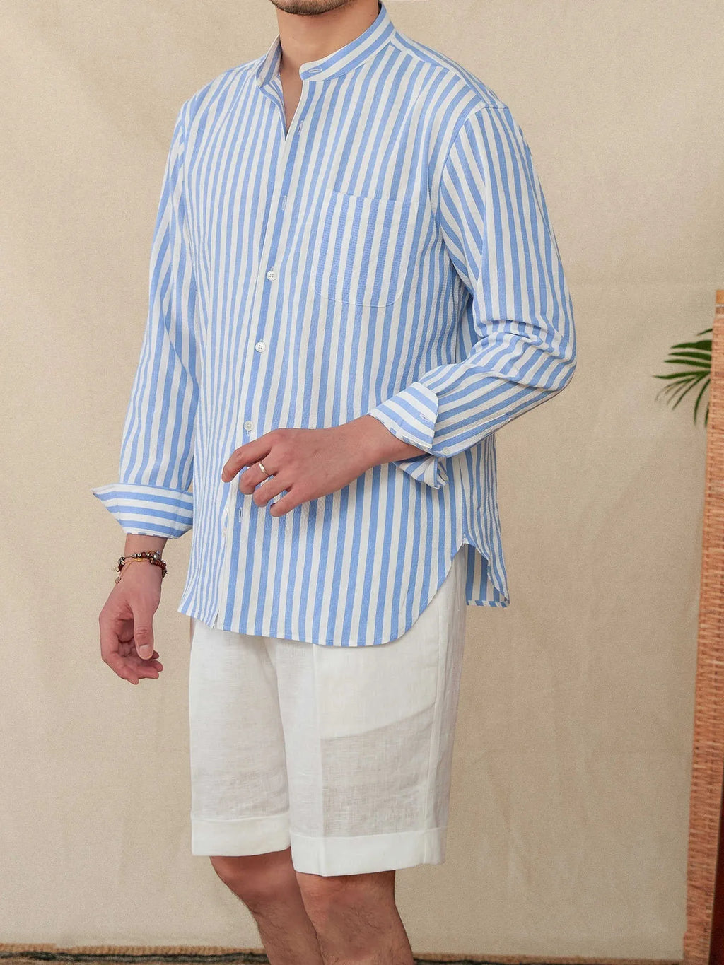 Blue and white seersucker striped long sleeve shirt with loose lapel collar on hanger