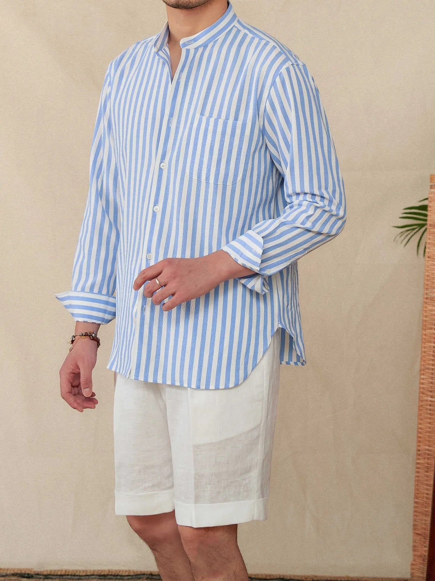 Blue and white seersucker striped long sleeve shirt with loose lapel collar on hanger