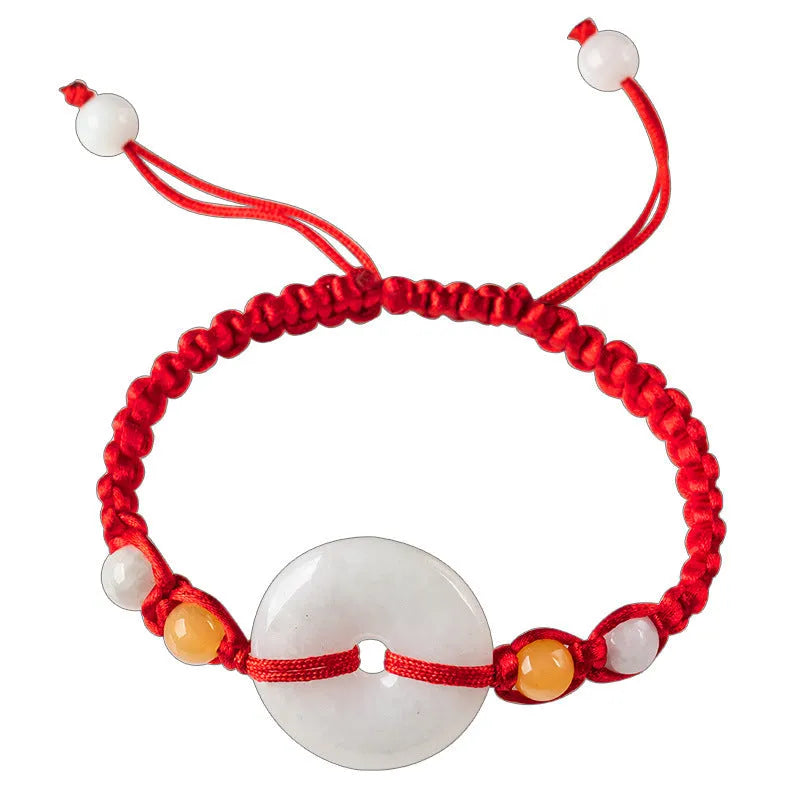 Round emerald green Burma jade pendant on an adjustable red rope bracelet strap.