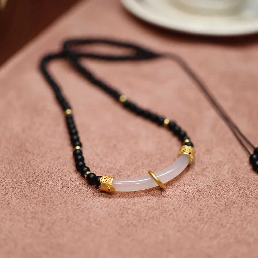 Chinese style U-shaped frosted black agate and white chalcedony necklace on beaded silver chain.